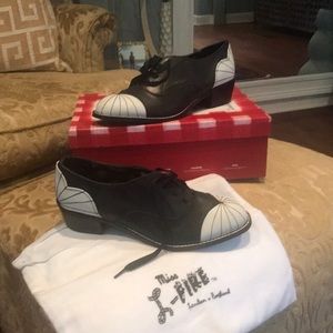 Black and white saddle shoes with tie and string.